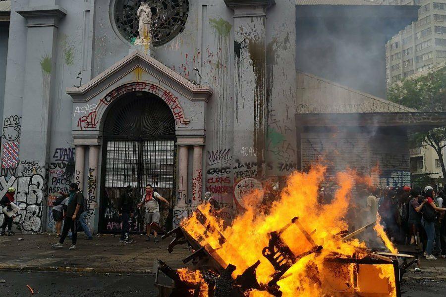 Manifestantes profanan iglesias en Chile: los fieles las restauran
